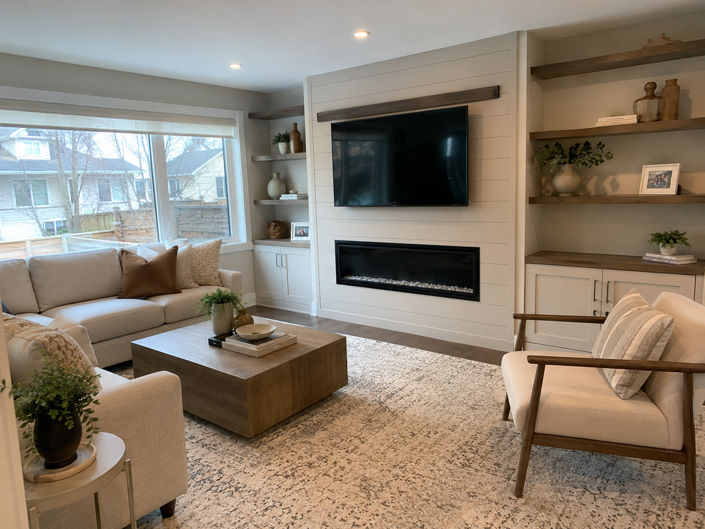 Bright open living room with sectional sofa and built-in fireplace shelving